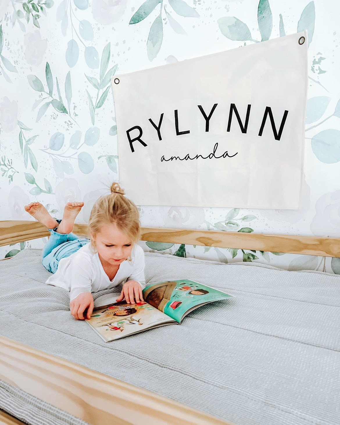 Custom canvas baby name banner with the name Rylynn Amanda hanging on wall in child's bedroom