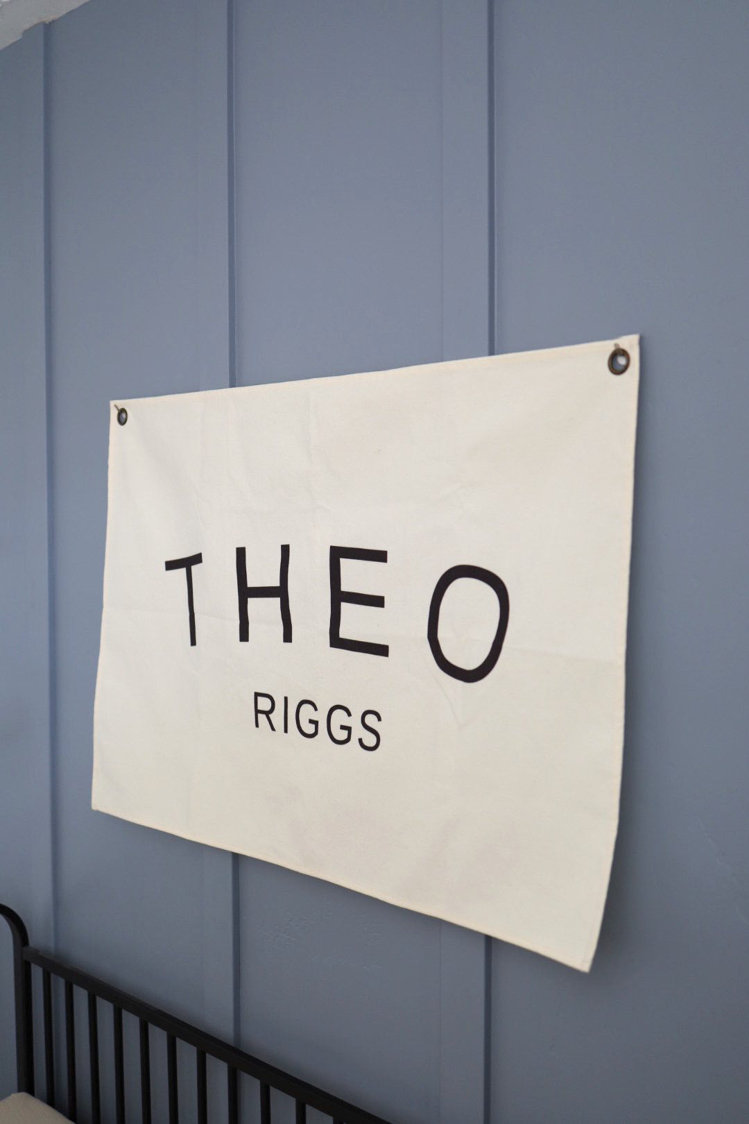 Custom canvas baby name banner with the name Theo Riggs printed in black letters on white canvas