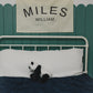 Custom canvas baby name banner with the name Miles William hanging above a white bed with a stuffed panda